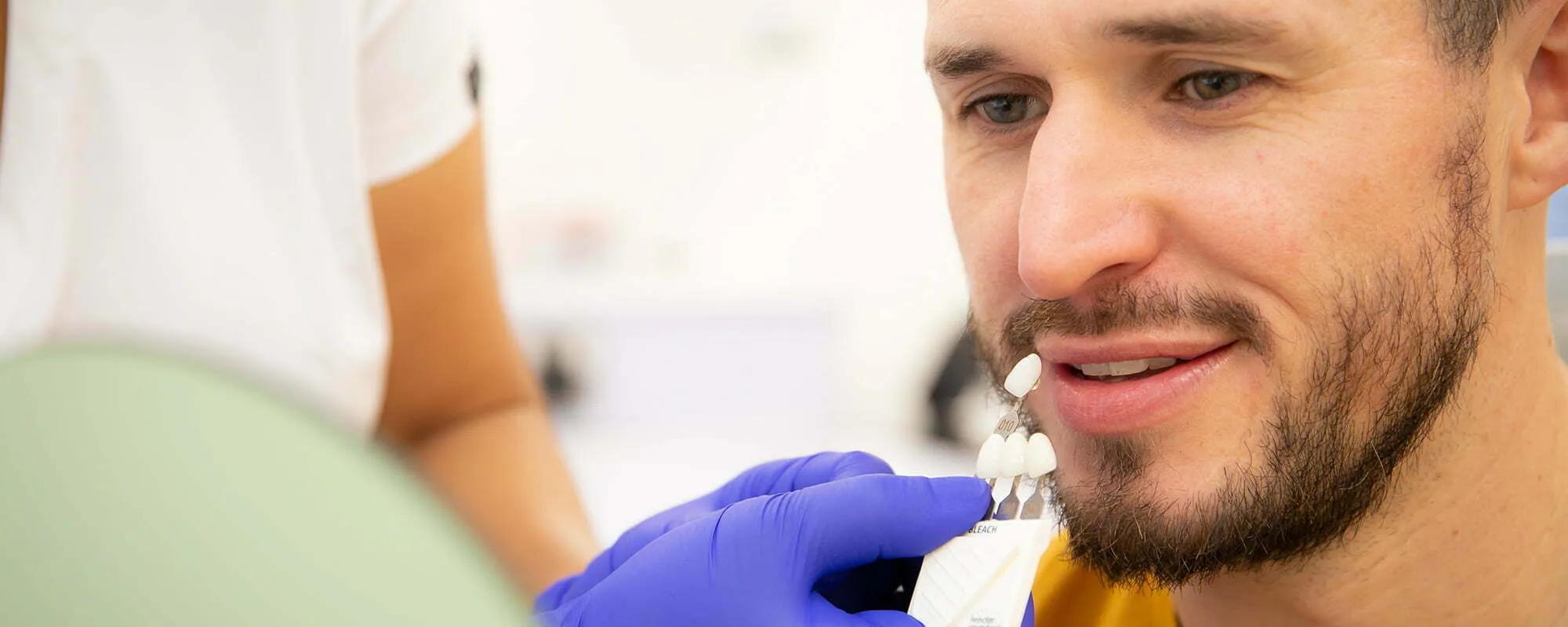 A dentist matching a veneer shade for a patient