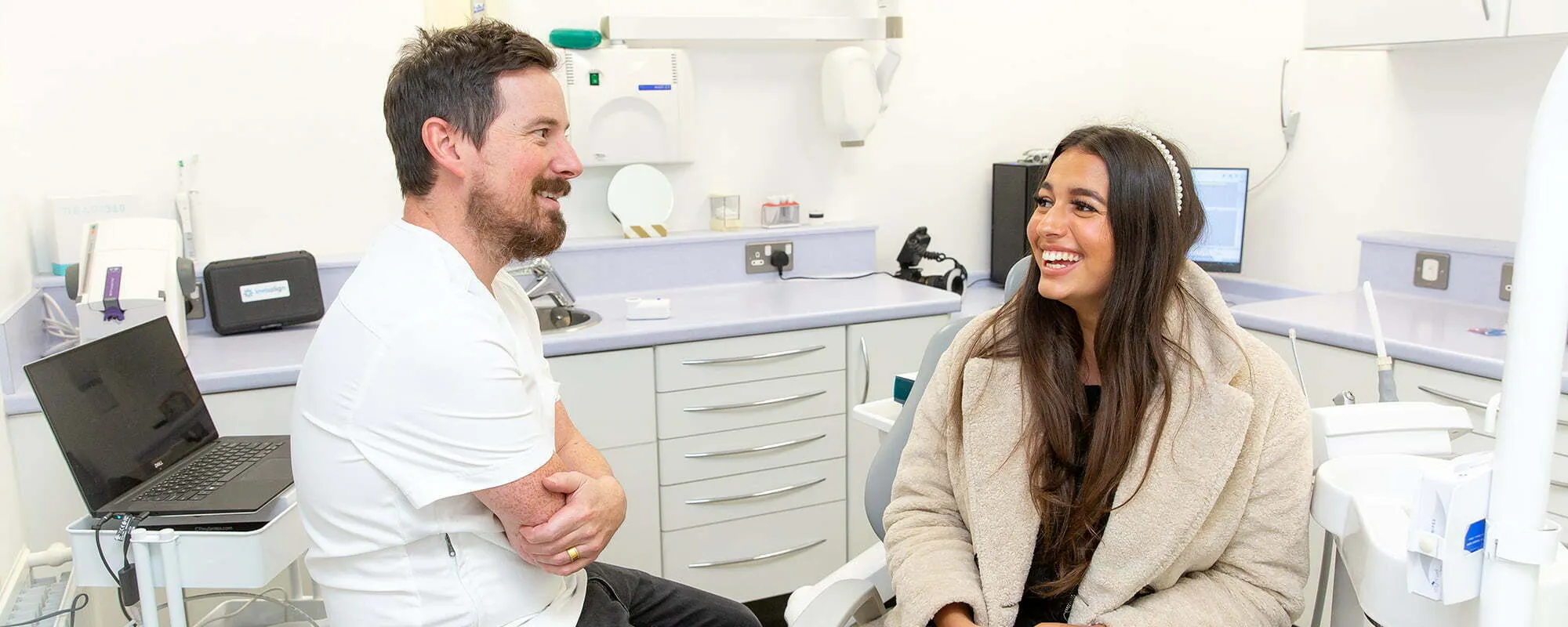 A dentist and patient sharing a laugh during a consultation