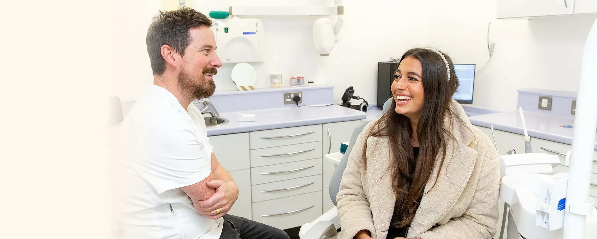 A dentist talking with a patient in the treatment room at Kings Hill Dental